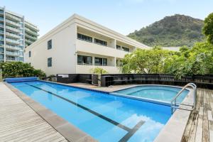 a swimming pool in front of a building at Oceanside Bliss - Absolute Beachfront - Uninterrupted Ocean Views with Pool in Mount Maunganui