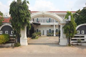 a large white building with an arch in front of it at OYO 1456 Hotel Garuda in Lampung