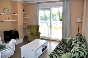 uma sala de estar com um sofá e uma televisão em Brisas A1, 2 dormitorios, playa a 50m, by Bookindenia em Denia