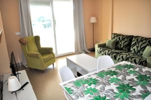 uma sala de estar com um sofá e uma mesa em Brisas A1, 2 dormitorios, playa a 50m, by Bookindenia em Denia