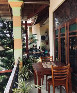 a patio with a wooden table and chairs on a balcony at Bee Nest Bed & Breakfast in Negombo