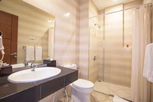 a bathroom with a sink and a toilet and a shower at Kuta Central Park Hotel in Kuta