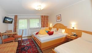 A bed or beds in a room at Ski in Ski out Hotel Unterellmau