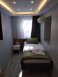 Habitación pequeña con cama y ventana en Hotel Tulip House, en Estambul