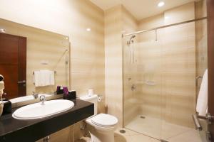 a bathroom with a toilet and a sink and a shower at Kuta Central Park Hotel in Kuta