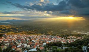 an aerial view of a city with the sun setting at Hotel Bia Maore in Baunei