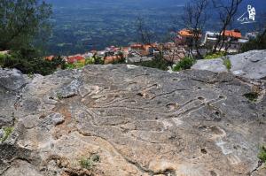 a rock with a snake carved into it on a mountain at Hotel Bia Maore in Baunei