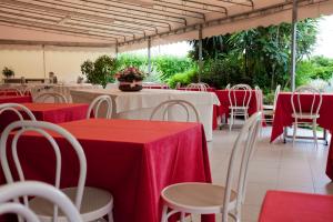 a group of tables and chairs with red table cloths at Grappolo D'Oro in Pietrasanta