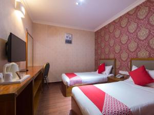 Tempat tidur dalam kamar di Super OYO 998 Queen City Hotel