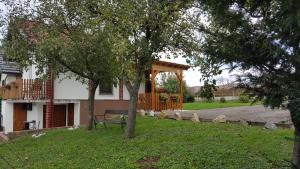 una casa con un banco en un patio con árboles en Kuca za odmor Vinica breg en Varaždin