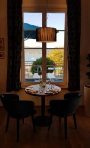 a dining room with a table and chairs and a window at VILLA LINDE Seehotel in Bodman-Ludwigshafen