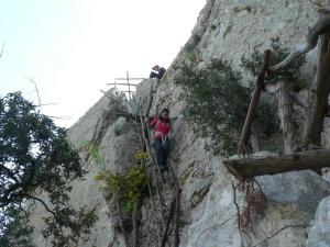 a person climbing up a mountain on a ladder at Hotel Bia Maore in Baunei