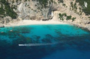 an aerial view of a beach with a boat in the water at Hotel Bia Maore in Baunei