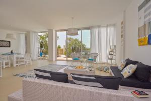a living room with a couch and a table and chairs at CASA sugli SCOGLI in Fontane Bianche