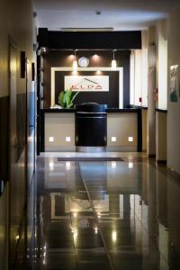 a lobby with a counter with a clock on the wall at Hotel Elda in Bydgoszcz