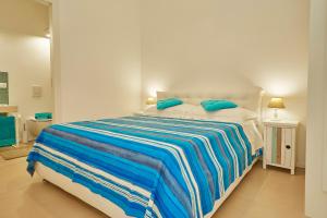 a bedroom with a large bed with blue pillows at CASA sugli SCOGLI in Fontane Bianche