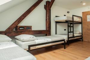 a room with three bunk beds in a attic at Hostel Vila Pohorje in Slovenj Gradec