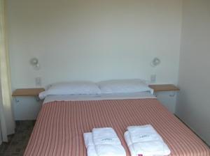 a bedroom with a bed with two towels on it at Complejo Hueney in Mar de Ajó