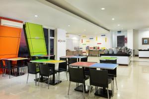 a cafeteria with tables and chairs and a kitchen at Amaris Hotel Pemuda Semarang in Semarang