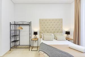 a white bedroom with a large bed and two lamps at LEEWAYS APARTMENT XVIII in GRAN VÍA in Madrid