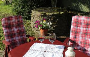 una mesa roja con dos copas de vino. en Ferienwohnung Ostwind, en Schüller