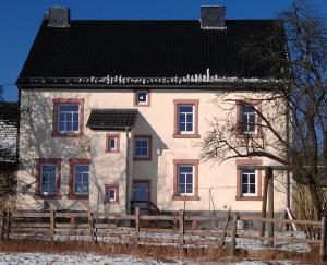 una casa grande con una valla delante en Ferienwohnung Ostwind, en Schüller