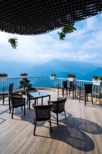 a patio with tables and chairs and a view of the mountains at Amazing Hotel Sapa in Sapa +119 photos