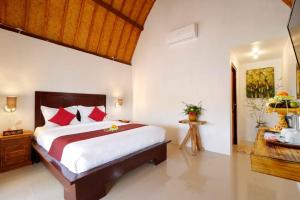 1 dormitorio con 1 cama grande con almohadas rojas en Temeling Jungle Inn en Nusa Penida