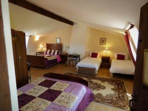 um quarto com duas camas e uma mesa num quarto em L'Ancien Presbytère Chambres D'hote ou Gite em Le Dorat