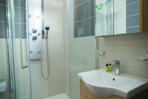 a bathroom with a shower and a sink and a shower at METOHI INN in Palaios Agios Athanasios