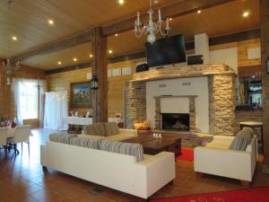 a living room with a fireplace and a couch and chairs at Holiday Village Tahko-Tours in Tahkovuori
