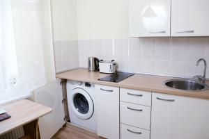 a kitchen with a sink and a washing machine at My Place, studio apartment in Visaginas