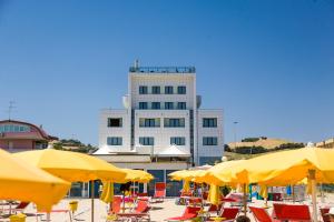 a building with yellow umbrellas in front of a beach at Hotel Royal in Fermo