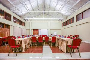 una sala de conferencias con mesas y sillas rojas en Maxland Hotel en Nairobi