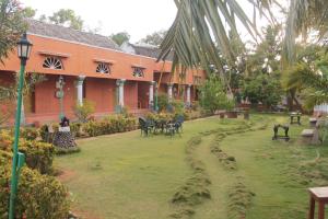 a yard with chairs and tables in front of a building at Chettinadu Court- HERITAGE VIEW in Kānādukāttān