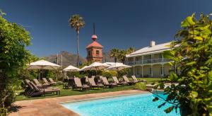 a resort with a swimming pool and chairs and a building at Dock House Boutique Hotel and Spa by NEWMARK in Cape Town
