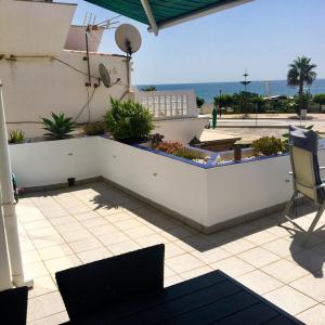 een patio met een tafel en stoelen en de oceaan bij Casa Pammy in Málaga
