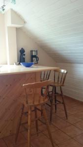 a table and two chairs at a counter in a attic at Pension Rosenblick in Mörlenbach