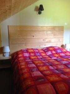 Una cama con un edredón colorido en un dormitorio en Le Chalet des Neiges, en Thiéfosse