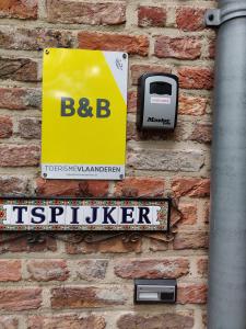 a sign on the side of a brick wall at B&B Tspijker in Mol