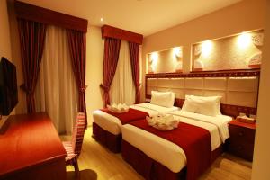 Giường trong phòng chung tại Al Liwan Suites Rawdat Al Khail