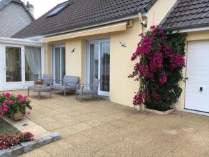 a house with flowers on the side of it at La Maison s'apelle le P'tit Nid in Granville