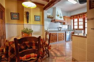 a kitchen with a table and chairs in a room at La Casa del Paseo in Baños de la Encina