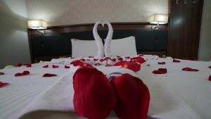 埃爾比勒的住宿－班諾酒店，一张床上有红色玫瑰花瓣的床