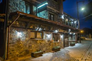 a stone building with lights on it at night at METOHI INN in Palaios Agios Athanasios