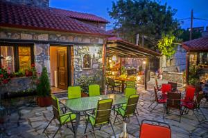 une terrasse avec une table et des chaises devant un bâtiment dans l'établissement METOHI INN, à Palaios Agios Athanasios