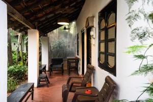 a porch of a house with chairs and tables at Rodrigues Guest House in Calangute
