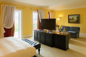 a bedroom with a bed and a tv and a couch at The Yeatman in Vila Nova de Gaia