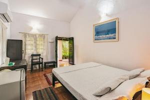 - une chambre avec un lit et une télévision à écran plat dans l'établissement Rodrigues Guest House, à Calangute