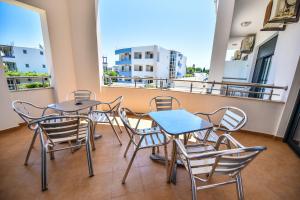 a balcony with two tables and chairs and a window at Apartments Laguna in Ulcinj